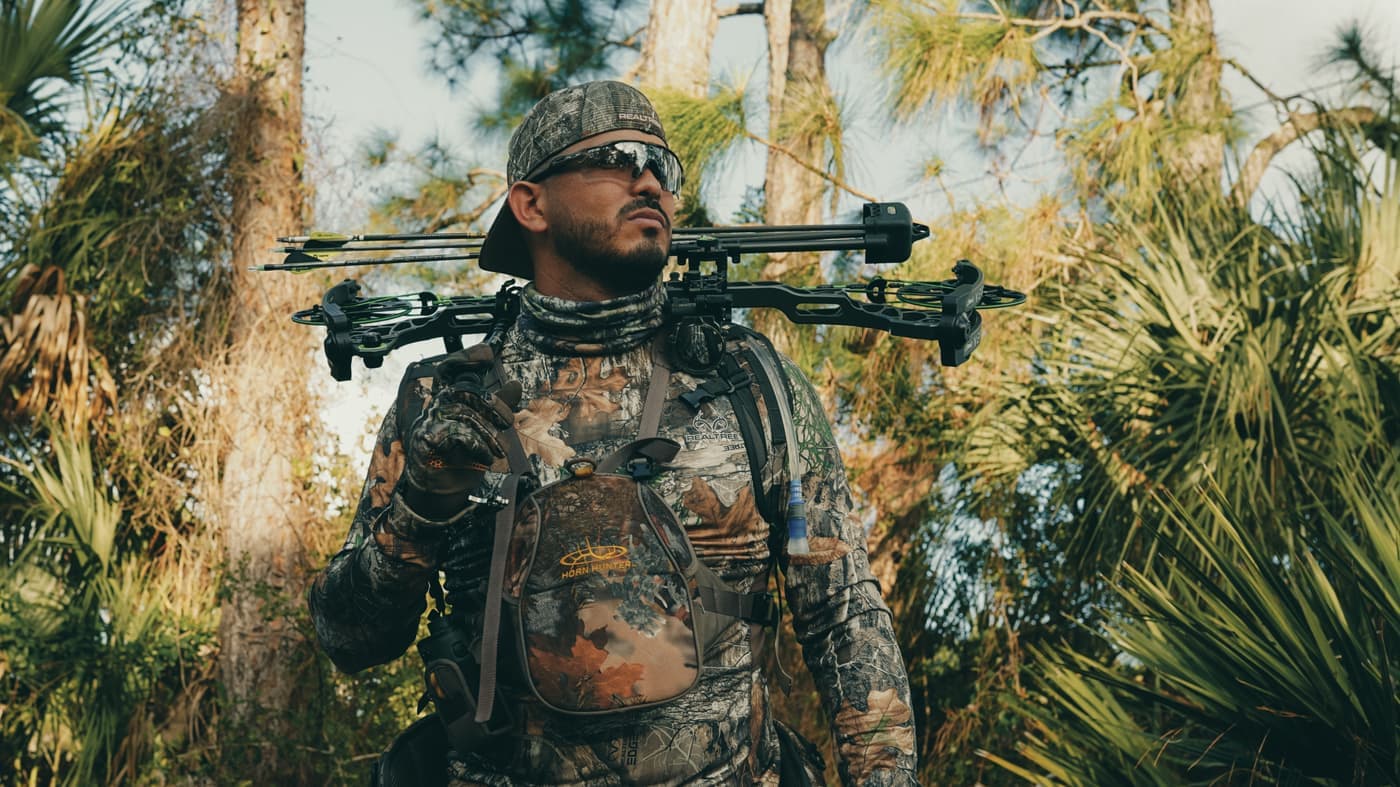 A new hunter checking a gear checklist at the tailgate of a truck before dawn